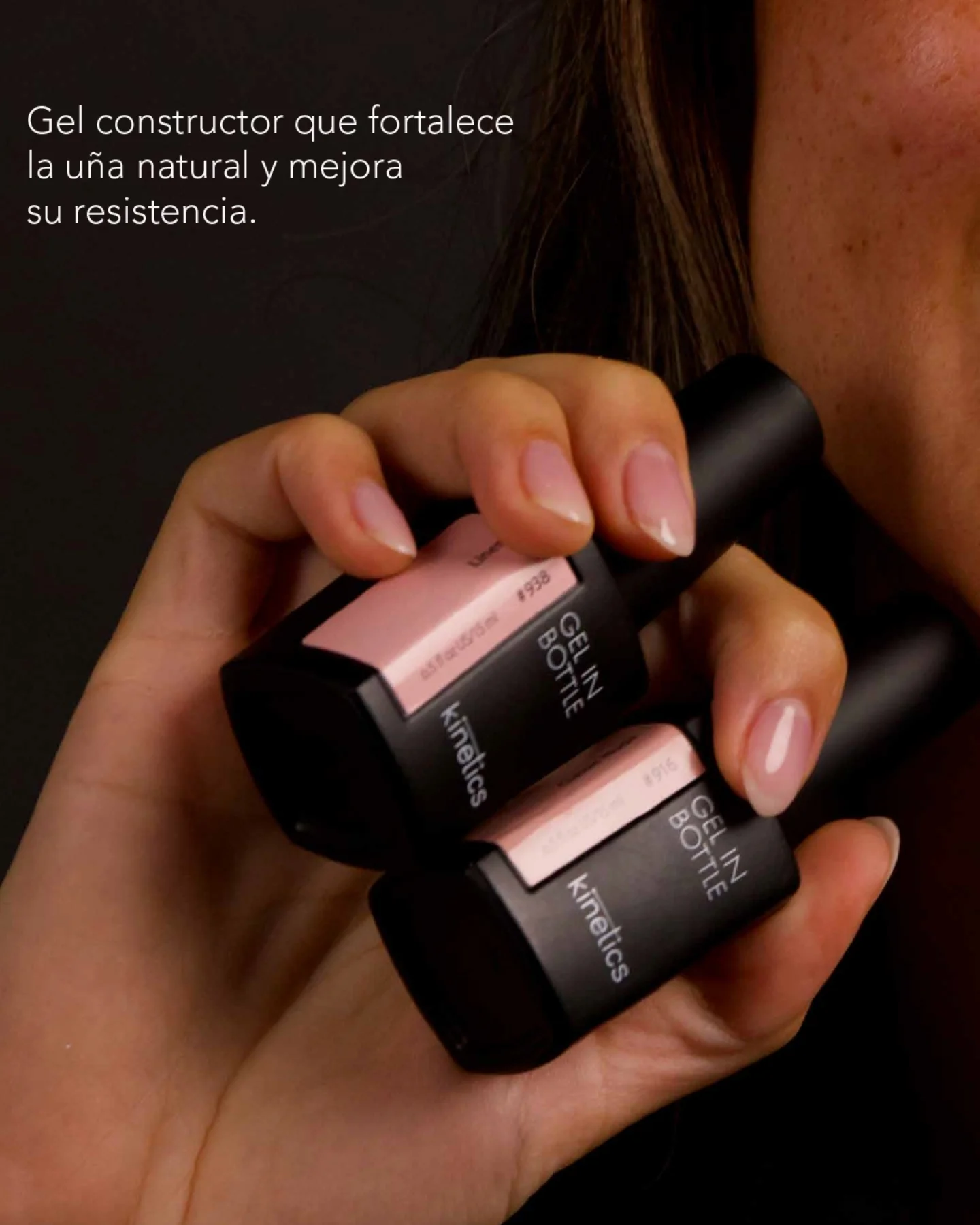 Dos frascos rosados de Gel in Bottle sostenidos en la mano