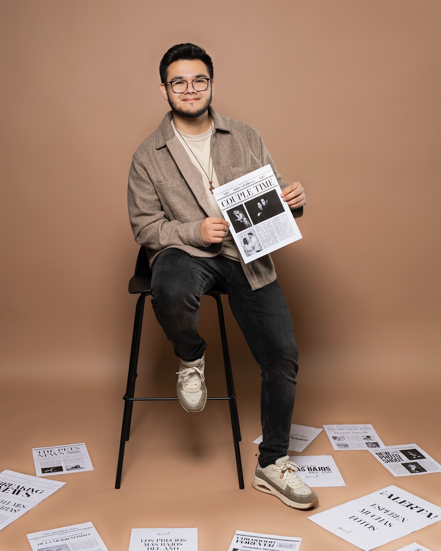 Modelo sentado con el periodico de sesiones de pareja